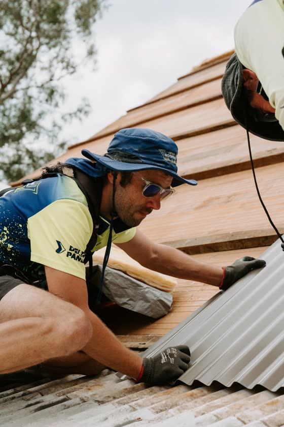 Roofer laying new roof sheets