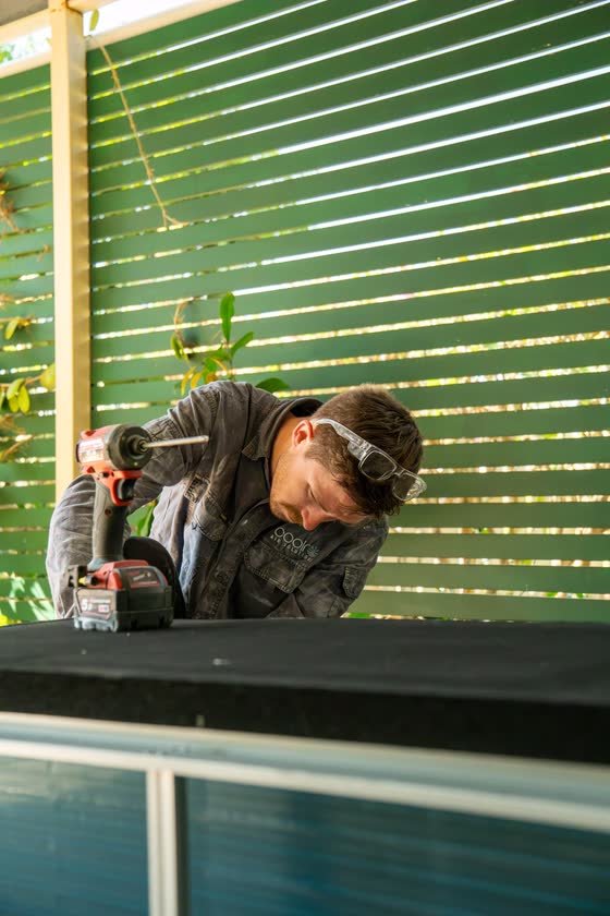 Carpenter cutting timber battens on site