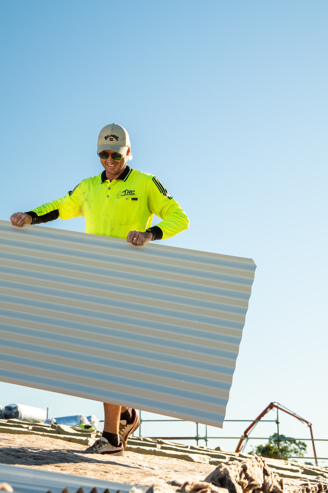 TNC Metal Roofing roofer carrying a roof sheet